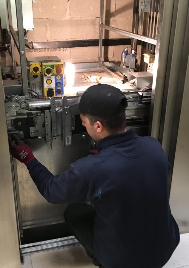 Photo d'un technicien qui répare un ascenseur